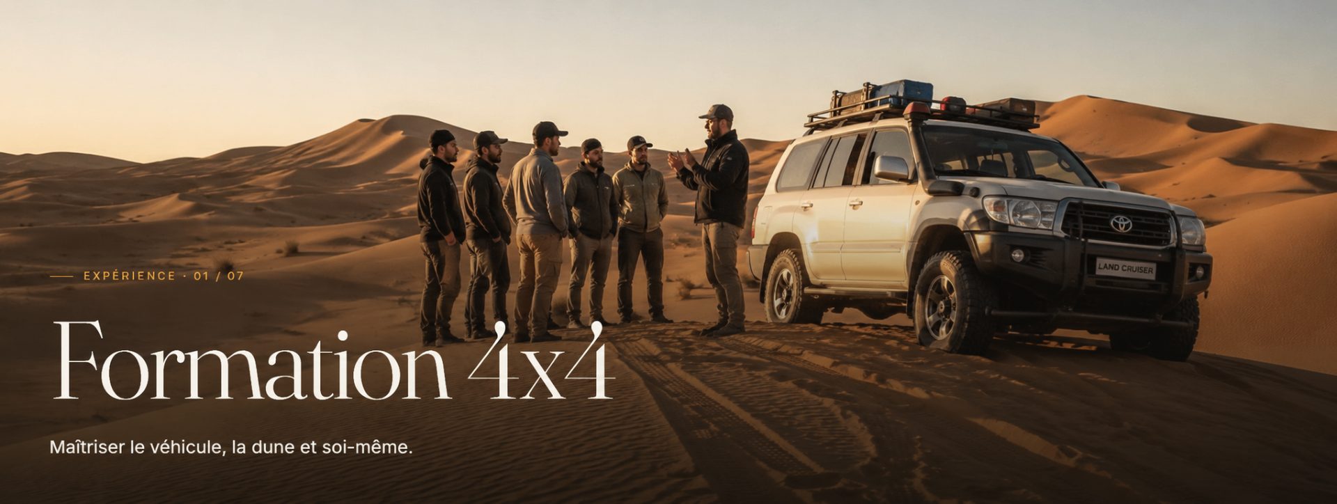 Ali briefant un groupe de pilotes près d'un Land Cruiser dans les dunes de Merzouga